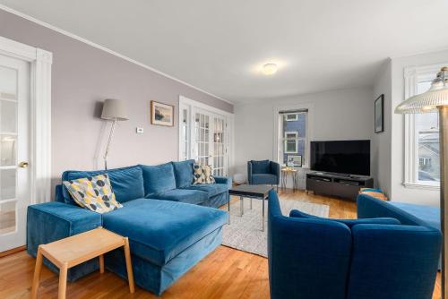 a living room with blue couches and a tv at Helena House in Gloucester