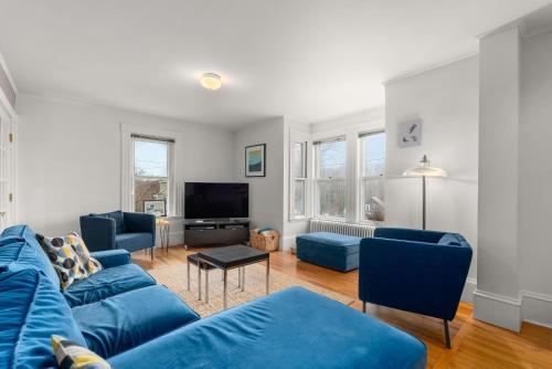 a living room with blue couches and a tv at Helena House in Gloucester