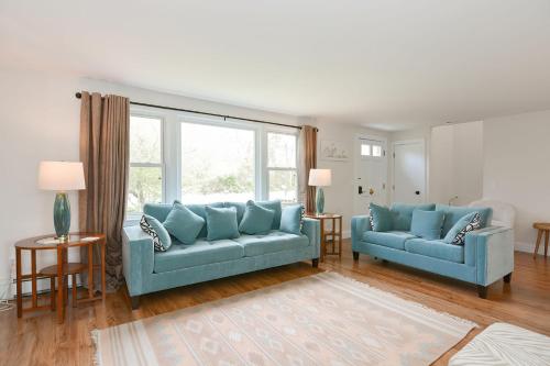 a living room with two blue couches and a window at Just For the Halibut in Rockport