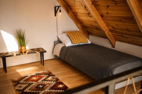 a attic room with a bed and a table at Osada Przejrzysko in Jordanów