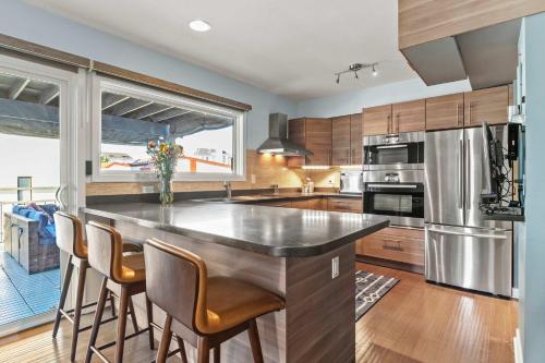 a kitchen with a large island with bar chairs at Spa Creek Condo Pool Deck & Parking in Annapolis