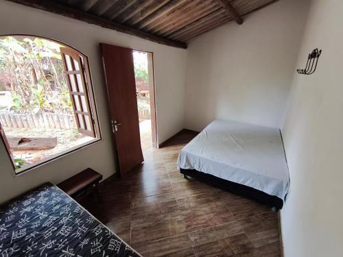 a bedroom with a bed and a large window at sitiolosbragas in Caetanópolis