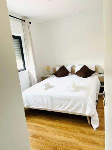a bedroom with a white bed and wooden floors at Casa Basáltico in Horta