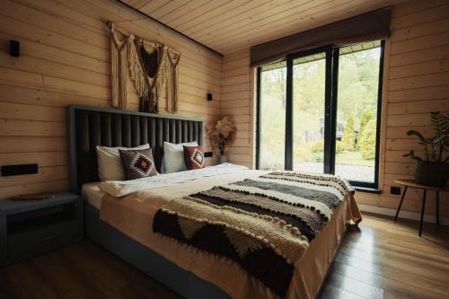 a bedroom with a bed in a room with wooden walls at Shale Maidan in Maidan Village