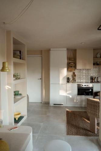 a living room with a kitchen with white cabinets at Playa del Ter in Platja de l'Arenal