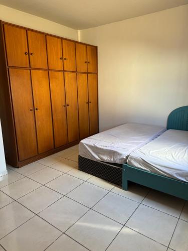 a bedroom with a bed and wooden cabinets at Prédio Solar da Serra in Parauapebas