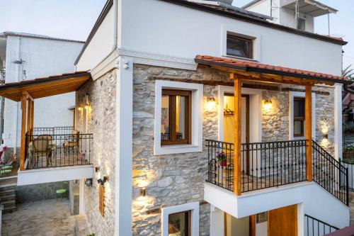 a small stone house with a balcony at Villa Arty in Limenaria