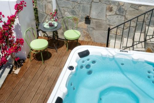 a hot tub on a deck with a table and chairs at Villa Arty in Limenaria