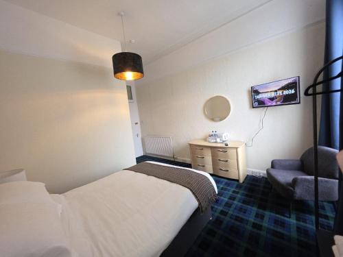 a hotel room with a bed and a chair at Waverley Hotel in Bonnyrigg