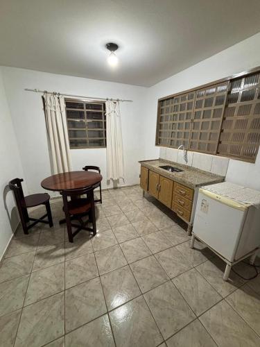 a kitchen with a table and a sink and a table at Pousada Rubbi Violeta in Alto Paraíso de Goiás