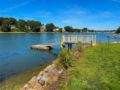 a dock on a lake with a grassy field at River Watch in Gloucester