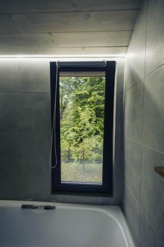 a bathroom with a window and a bath tub at Shale Maidan in Maidan Village