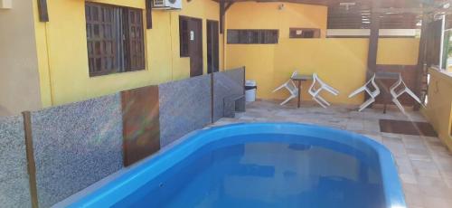 a swimming pool in a room with a table and chairs at Pousada dos Pássaros Pipa in Pipa