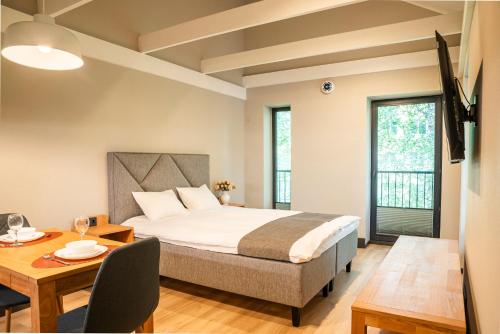 a bedroom with a bed and a table and chairs at Livonia Central Apartments in Valga