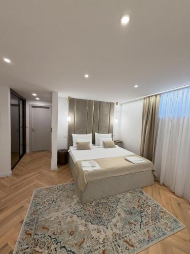 a large bedroom with two beds and a rug at The Elysium Rooms in Makarska