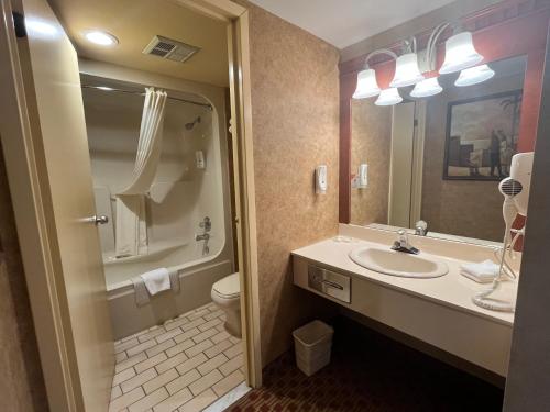 a bathroom with a sink and a toilet and a mirror at Quality Inn & Suites Bay Front in Sault Ste. Marie