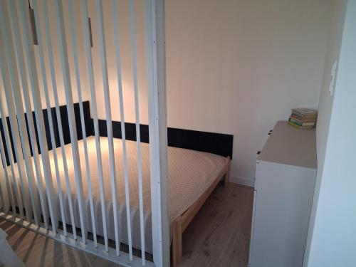 a crib in a small room with a bed at Diwo Apartament in Koszalin