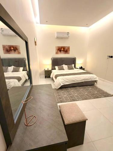 a large bedroom with two beds and a mirror at أورا ل التأجير اليومي للعائلات فقط in Jeddah