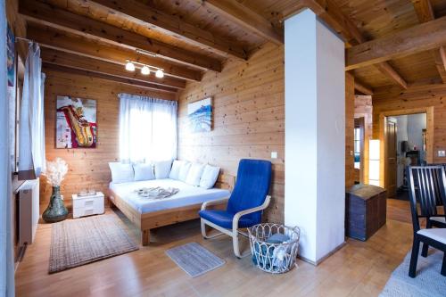 a living room with a white bed and a blue chair at Feel Good Place in Fritzens
