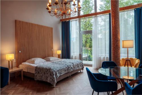 a bedroom with a bed and a table and chairs at Hotel New Wave Wisła in Wisła