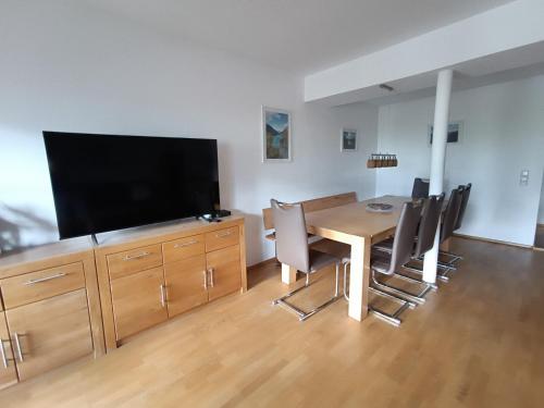 a dining room with a table and a flat screen tv at Panorama-Apartment Fürth in Aufhausen