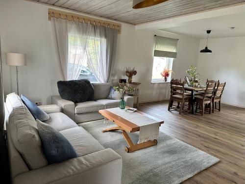 a living room with a couch and a table at Upeskrastu mājas in Vilcāni