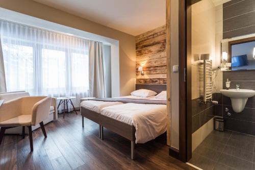 um quarto de hotel com uma cama e um lavatório em Walkowy Dwor em Zakopane