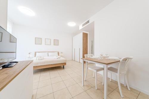 a white room with a table and chairs and a bed at Martesana47 - 5 Min S Raffaele e Linate Apt in Vimodrone