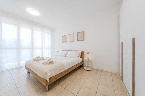a white bedroom with a large bed and a window at Martesana47 - 5 Min S Raffaele e Linate Apt in Vimodrone