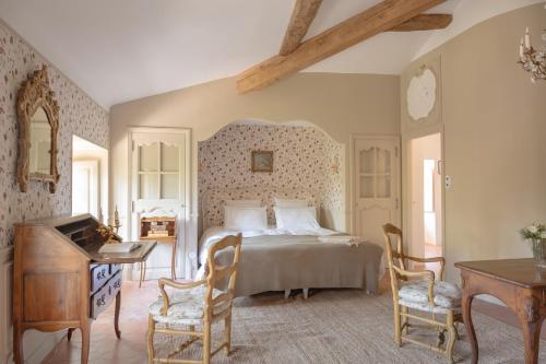 a bedroom with a bed and a desk and a piano at Château du Grand Pré in Vitrolles-en-Luberon