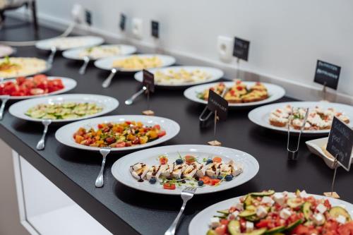 a buffet with plates of food on a table at Hotel New Wave Wisła in Wisła