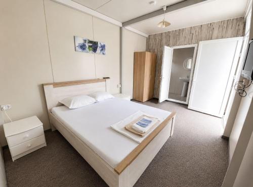 a bedroom with a large white bed in a room at Camping Bucuria Bungalow in Eforie Nord