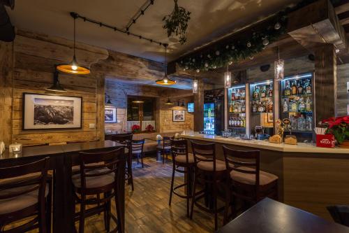 un bar in un ristorante con pareti in legno e sgabelli da bar di Walkowy Dwor a Zakopane
