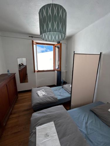 a room with three beds and a window at Beau Refuge du Galibier in Le Monêtier-les-Bains