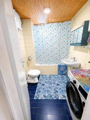 a bathroom with a toilet and a washing machine at Igalo Apartment in Igalo