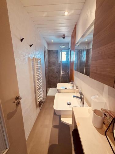 a bathroom with two sinks and a shower at Belle maison hyper centrale 3 chambres in Lagord