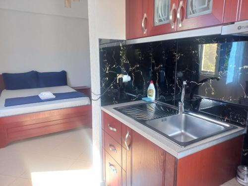 a small kitchen with a sink and a bed at Vila Ester in Ksamil