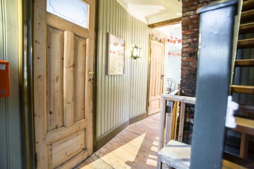 a hallway with a wooden door and a brick wall at Reykjavík Treasure B&B in Reykjavík