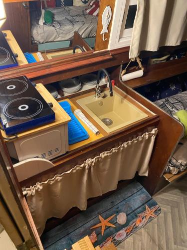 a kitchen counter with a sink and a stove at Original Friendly Boat in Sant Pau dʼOrdal