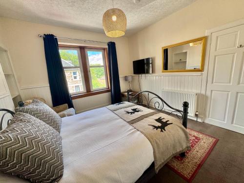 a bedroom with a large bed and a window at The Castle Front Nest in Inverness