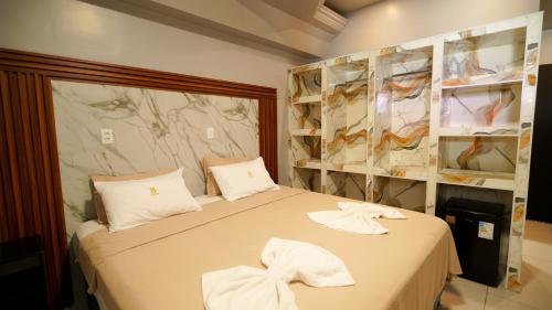 a bedroom with a bed with white towels on it at Barrudada Palace Hotel-Boa Vista in Boa Vista