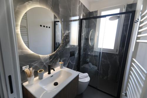 a bathroom with a sink and a mirror and a toilet at B&Suite Le Meraviglie in Terrasini