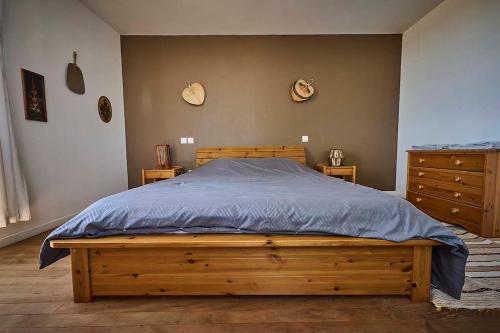 a bedroom with a wooden bed and a dresser at Gîte ferme équestre avec piscine in Castex