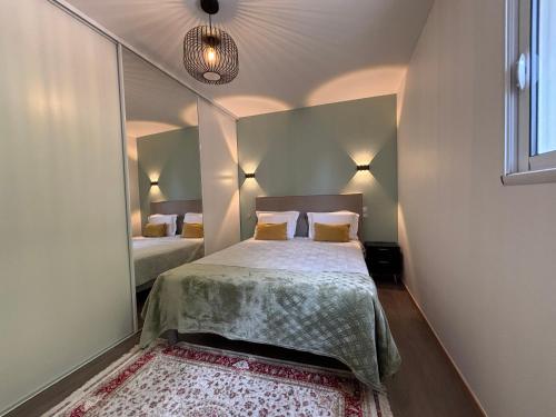 a small bedroom with a bed and a mirror at Bel Appartement Perrières in Brive-la-Gaillarde