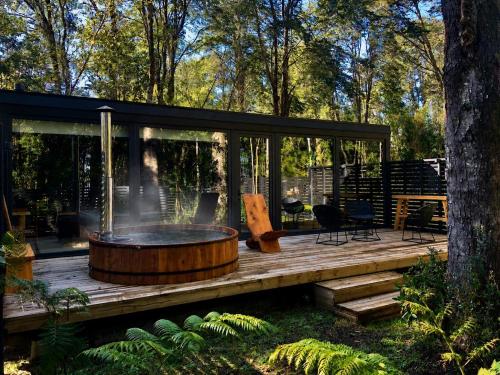 a screened in porch with a hot tub on a wooden deck at Calma Lodge in Puerto Clocker