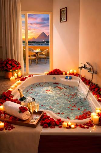 a jacuzzi tub in a hotel room with candles at MiRAGE PYRAMiDS HOTEL in Cairo