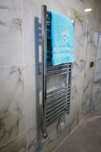 a bathroom with a shower with a blue towel at North Pearl Guesthouse in Porto Moniz