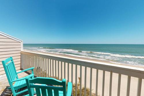 two blue chairs sitting on a balcony looking at the beach at Dune Our Thing in Kure Beach