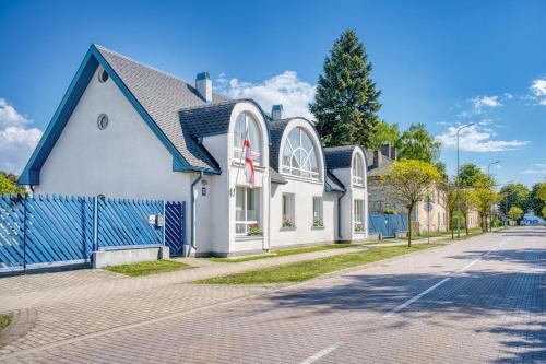 a white and blue building on a street at Jūras Vilks in Ventspils