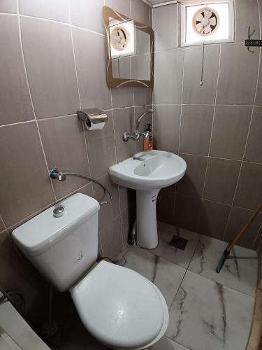 a bathroom with a toilet and a sink at Rousan House in Um Qeis